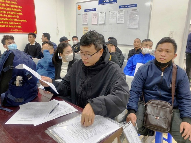 Người dân kiểm tra giấy tờ trước khi vào làm thủ tục cấp, đổi giấy phép lái xe. (Ảnh: Minh Sơn/Vietnam+) 2nguoidan.jpg