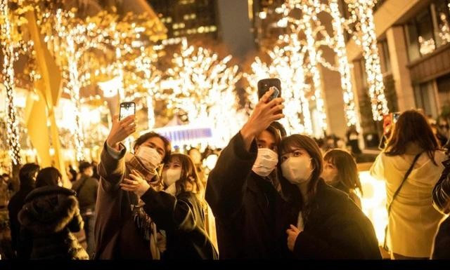 Các cặp đôi chụp ảnh trên đường phố Tokyo đêm Giáng sinh. ẢNH: AFP Các cặp đôi chụp ảnh trên đường phố Tokyo đêm Giáng sinh. ẢNH: AFP