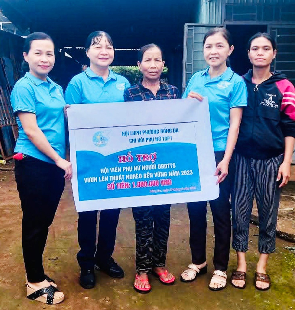 Bà Trịnh Thị Oanh (thứ 2 từ phải sang) trao bảng tượng trưng hỗ trợ tiền cho hội viên phụ nữ vươn lên thoát nghèo (ảnh nhân vật cung cấp). chi-hoi-truong-phu-nu-tan-tam-trach-nhiem-dd.jpg