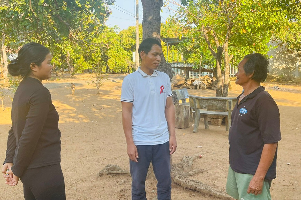 Anh Rơ Lan Xíu (giữa) trò chuyện cùng ông Hmơnh, người uy tín của làng Nú. Ảnh: A.H 3t.jpg