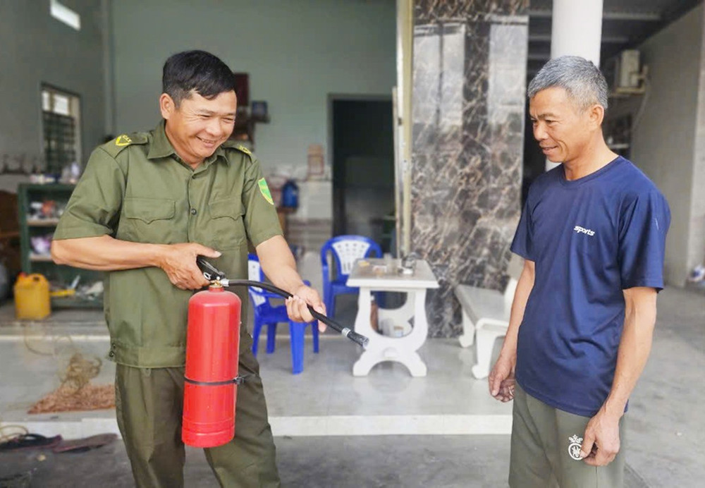 Ông La Văn Gia (bìa trái) hướng dẫn người dân sử dụng bình chữa cháy để phòng-chống cháy nổ. Ảnh: R.H 3h.jpg