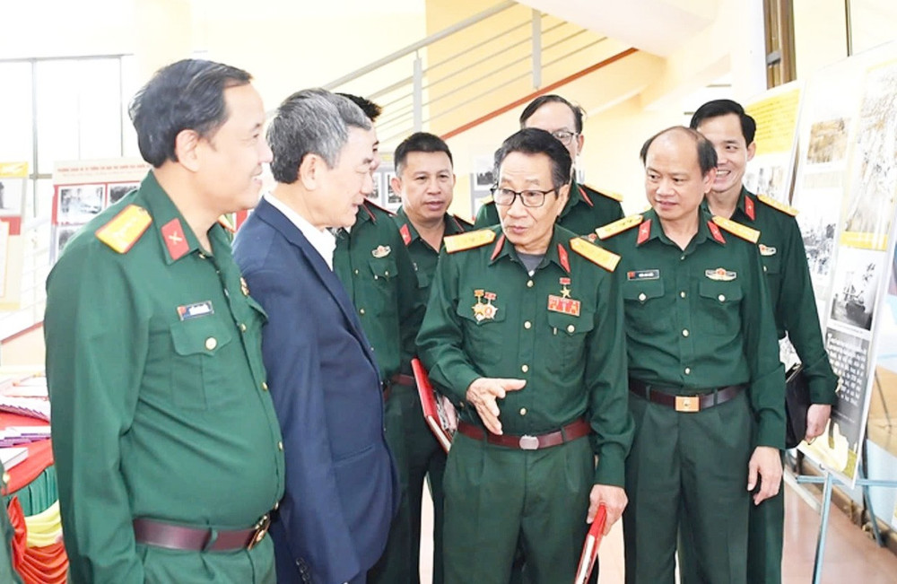 Anh hùng Lực lượng vũ trang nhân dân Nguyễn Vi Hợi (hàng trước, thứ 3 từ trái sang) trò chuyện với cán bộ Quân đoàn 34 . Ảnh: T.T ky-uc.jpg