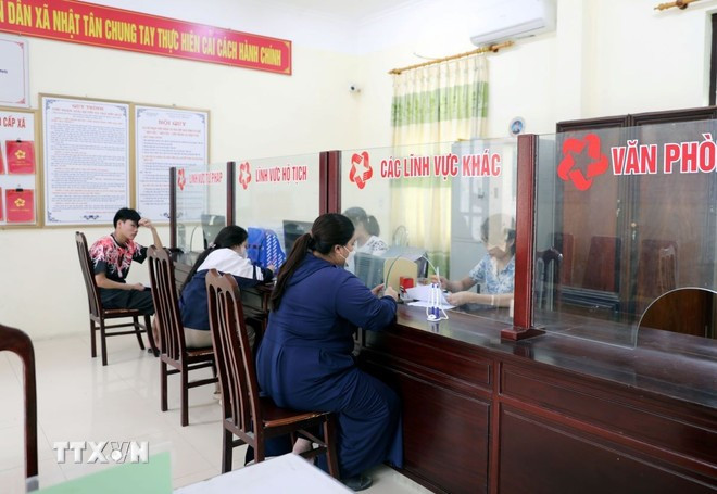 Người dân làm thủ tục hành chính tại bộ phận "một cửa" xã Nhật Tân, huyện Kim Bảng. Ảnh: Nguyễn Chinh/TTXVN 2sap-xep-don-vi-hanh-chinh-cap-xa-1603.jpg