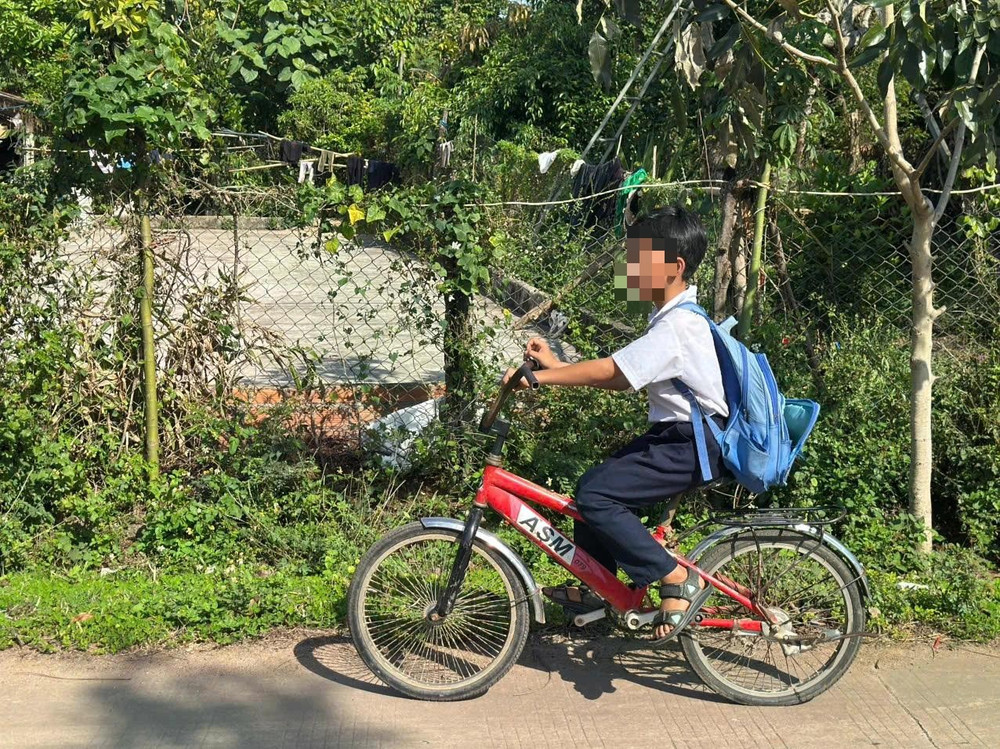 Cháu K. (10 tuỏi) trên chiếc xe đạp nhỏ đi tìm cha. ẢNH: T.X Cháu K. (10 tuỏi) trên chiếc xe đạp nhỏ đi tìm cha. ẢNH: T.X
