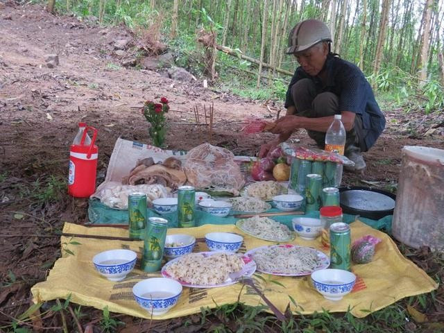 Ông Trần Sơn bày biện lễ vật cúng rừng rồi liên hoan với bà con đồng bào Hrê. ẢNH: TRANG THY 4lenrung.jpg