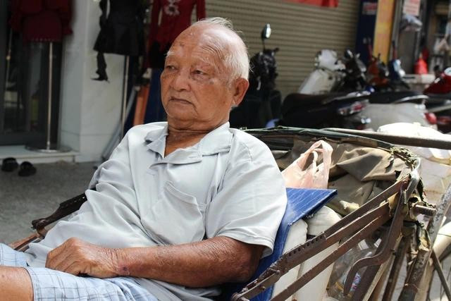 Cụ Chiêu đang ngồi trên chiếc xích lô chờ khách. ẢNH: QUANG VIÊN Cụ Chiêu đang ngồi trên chiếc xích lô chờ khách. ẢNH: QUANG VIÊN
