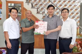 Phó Chủ tịch UBND tỉnh Lâm Hải Giang (thứ 2 từ phải sang) tặng quà cho thương binh Huỳnh Thạnh (ở thôn Nhơn Phước). Ảnh: CÔNG NÃNG