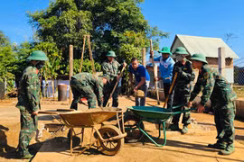 Cán bộ, chiến sĩ chung tay sửa chữa nhà cho người dân.