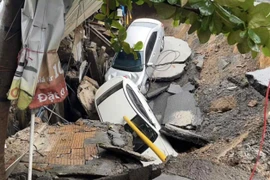 Hai ô tô bị "hố tử thần" nuốt chửng