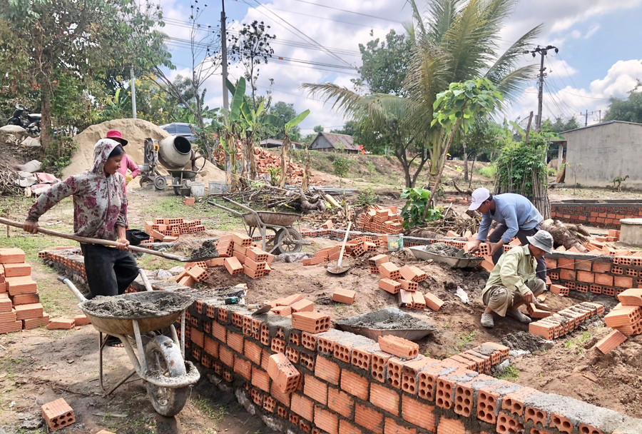 Gia đình bà Dáo tranh thủ tự phụ hồ cho thợ để giảm chi phí. Ảnh: Lê Nam bao-dao.jpg