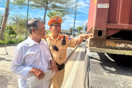 Cán bộ Đội Cảnh sát giao thông đường bộ số 4 nhắc nhở tài xế về các điểm chưa đảm bảo tại chốt giữ của container. Ảnh: K.A