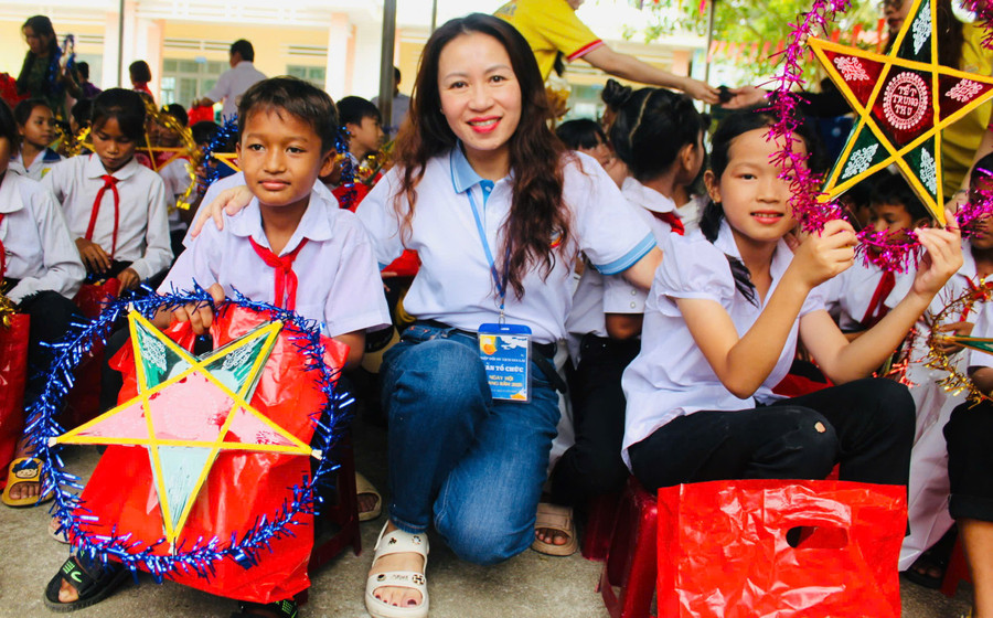 Em Đinh Siu Nhin (bìa trái) và các bạn học sinh Trường Tiểu học Lê Văn Tám vui mừng nhận quà từ bà Hoàng Thị Sen, Phó Chủ tịch Hiệp hội Du lịch Bình Định (cũ). Ảnh: Vũ Chi gen-h-z7081122184976-d75783dd5dd5957efb6ad41b83d11ff1.jpg