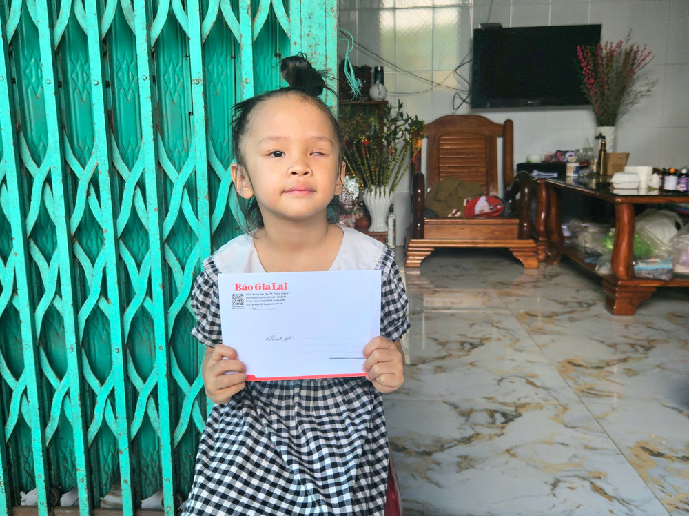 Cháu Đặng Trần Di Nhiên nhận tiền hỗ trợ từ Báo Gia Lai và bạn đọc. Ảnh: Ngọc Duy 20250424-133134.jpg