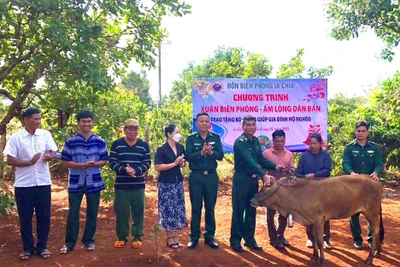 Cán bộ Đồn Biên phòng Ia Chía và đại diện chính quyền địa phương trao bò giống cho hộ ông Kih.