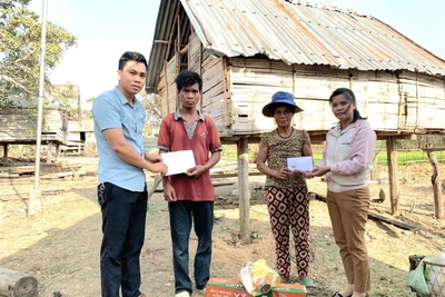 Hội Nông dân và Hội Phụ nữ xã trao kinh phí hỗ trợ cho gia đình anh Yeng bên căn nhà nhỏ do bà con trong thôn dựng tạm giúp gia đình có chỗ che mưa, che nắng. Ảnh: Đức Chiến