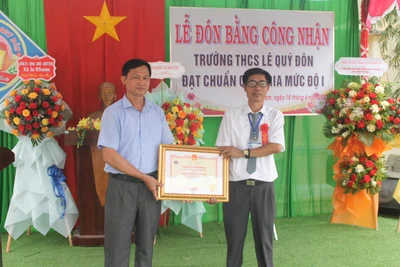 Phó Chủ tịch UBND huyện Krông Pa Nguyễn Tiến Đãng (bìa trái) trao bằng công nhận Trường đạt chuẩn quốc gia mức độ 1. Ảnh: Vũ Chi