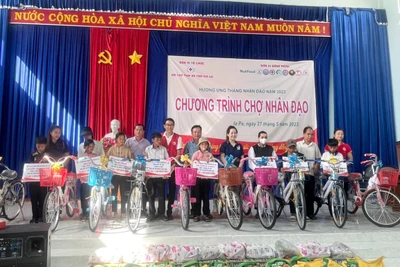 Ban tổ chức trao tặng 10 chiếc xe đạp cho 10 em học sinh vượt khó vươn lên trong học tập của Trường Tiểu học và THCS Phạm Hồng Thái. Ảnh: Vũ Chi