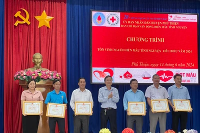 Phó Chủ tịch Thường trực UBND huyện Nguyễn Ngọc Ngô (đứng giữa) tặng giấy khen cho 6 tập thể có thành tích xuất sắc trong công tác hiến máu tình nguyện. Ảnh: Vũ Chi