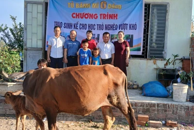 Tủ bánh mì 0 đồng phối hợp với UBND xã Chư Băh, Ban Giám hiệu Trường Tiểu học Bùi Thị Xuân trao cặp bò mẹ con cho em Ngô Đăng Khoa (lớp 3A, Trường Tiểu học Bùi Thị Xuân). Ảnh: Vũ Văn Tùng