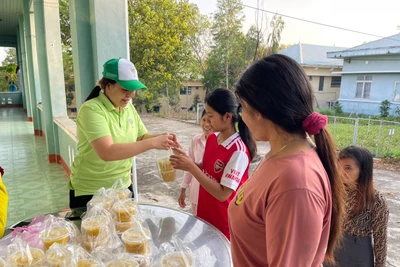 Chị Nguyễn Thị Tâm (bìa trái) cẩn thận đóng hũ từng suất ăn sáng trước khi phát cho bệnh nhân. Ảnh: Vũ Chi