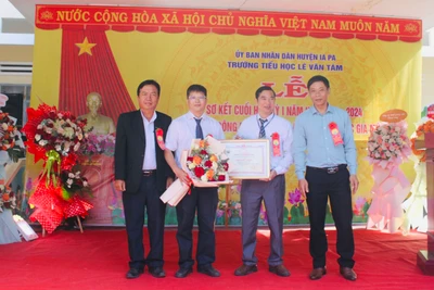 Bí thư Huyện ủy Nguyễn Minh Trưởng (bìa phải) và Phó Chủ tịch UBND huyện Ksor Suy (bìa trái) trao bằng công nhận Trường đạt chuẩn quốc gia mức độ 1 cho Trường Tiểu học Lê Văn Tám. Ảnh: Vũ Chi