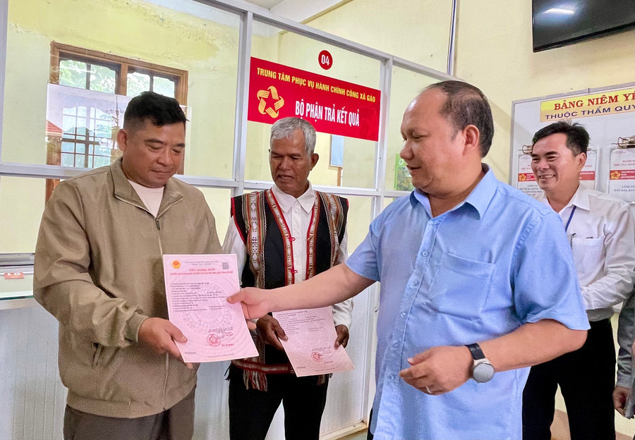 Phó Bí thư Thường trực Tỉnh ủy, Chủ tịch HĐND tỉnh Rah Lan Chung trao giấy chứng nhận quyền sử dụng đất, quyền sở hữu tài sản gắn liền với đất đầu tiên do cấp xã cấp cho 2 người dân trên địa bàn xã Gào. Ảnh: Vũ Thảo 22.jpg