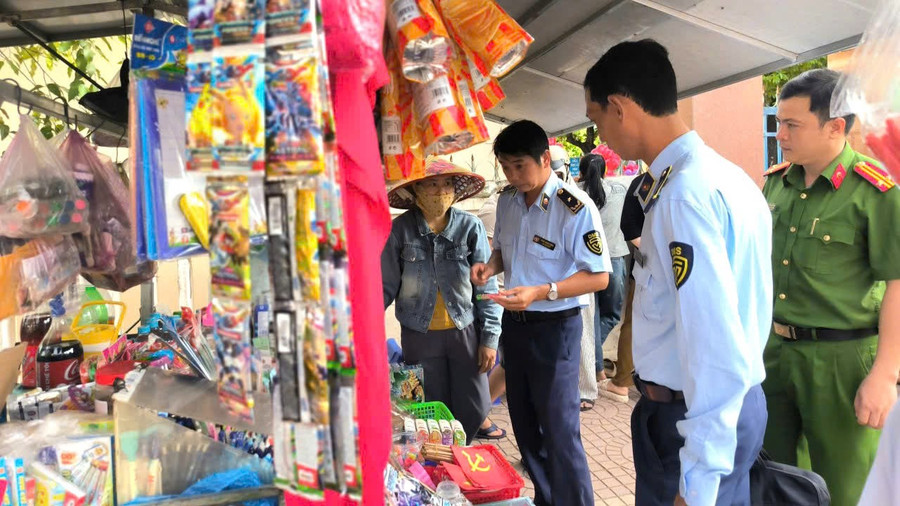 Lực lượng Quản lý thị trường phối hợp với lực lượng Công an tuyên truyền tại cơ sở buôn bán xung quanh khu vực Trường Tiểu học số 1 phường Bình Định. Ảnh: ĐVCC anh-dvcc-3319.jpg