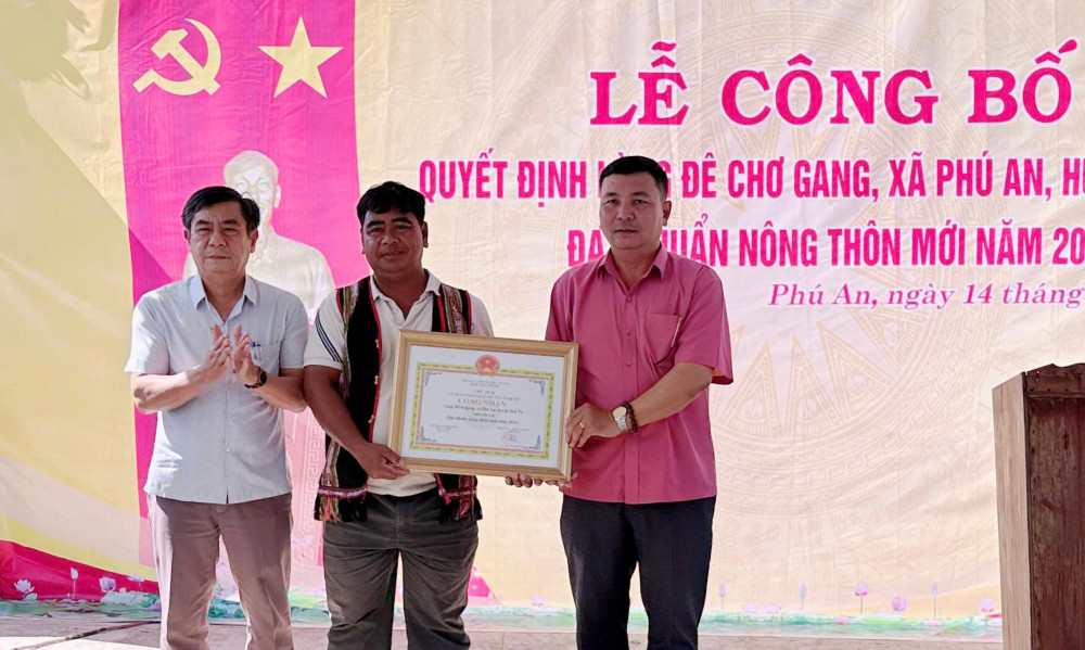 Lãnh đạo UBND huyện Đak Pơ trao Quyết định công nhận làng Đê Chơ Gang đạt chuẩn nông thôn mới. Ảnh: Lan Anh z6405978375169-5e569274cf40509483b6f14889b9d18c.jpg