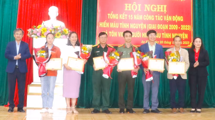 Ông Nguyễn Xuân Phước (bìa trái)-Tỉnh ủy viên, Bí thư Thị ủy An Khê và bà Lê Thị Hồng Minh (bìa phải)-Phó Chủ tịch UBND thị xã An Khê tặng giấy khen cho đại diện các tập thể. Ảnh: Ngọc Minh