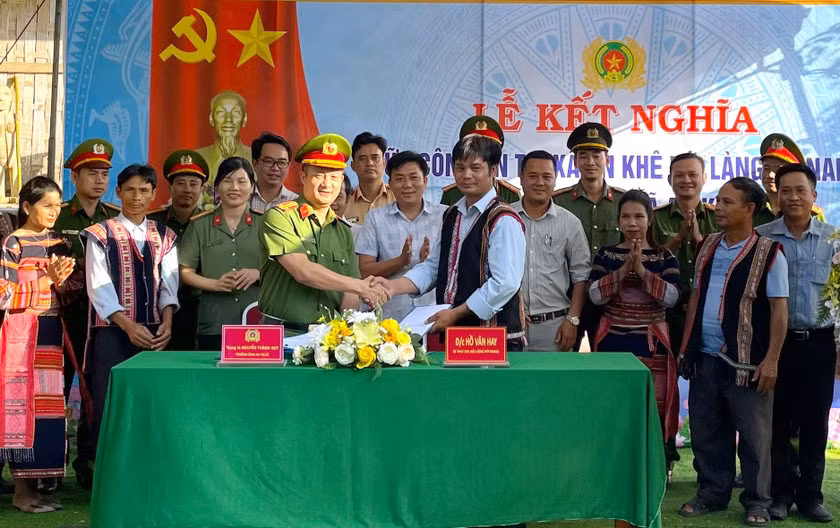 Lãnh đạo Công an thị xã An Khê và đại diện làng Pơ Nang (xã Tú An) ký kết bản giao ước kết nghĩa. Ảnh: Ngọc Minh