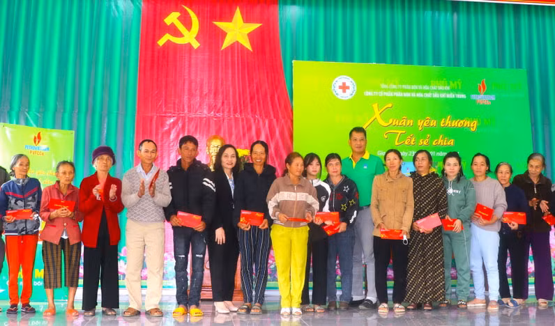 Bà Lê Thị Hồng Minh (thứ 6 bên trái)-Phó Chủ tịch UBND thị xã An Khê cùng đại diện Công ty cổ phần Phân bón và Hóa chất dầu khí Miền Trung trao quà cho hộ nghèo, cận nghèo. Ảnh: Ngọc Minh