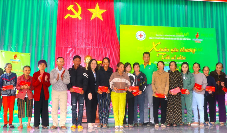 Bà Lê Thị Hồng Minh (thứ 6 bên trái)-Phó Chủ tịch UBND thị xã An Khê cùng đại diện Công ty cổ phần Phân bón và Hóa chất dầu khí Miền Trung trao quà cho hộ nghèo, cận nghèo. Ảnh: Ngọc Minh