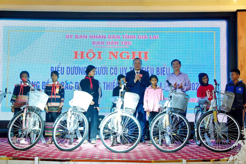 Phó Chủ tịch UBND tỉnh Dương Mah Tiệp và Phó Tổng Biên tập Báo Gia Lai Đoàn Minh Dưỡng trao xe đạp cho các em học sinh nghèo vượt khó. Ảnh: Đức Thụy