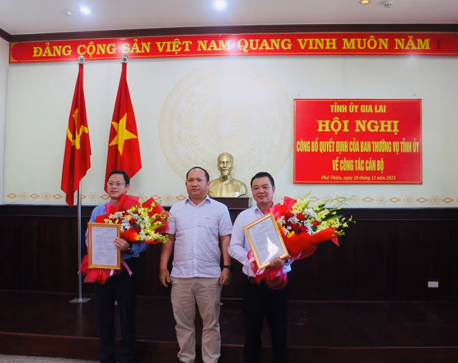 Phó Bí thư Tỉnh ủy Rah Lan Chung (đứng giữa) trao quyết định và tặng hoa chúc mừng đồng chí Nguyễn Hoàng Phong (bìa trái) và Vũ Hồng Duy. Ảnh: Vũ Chi