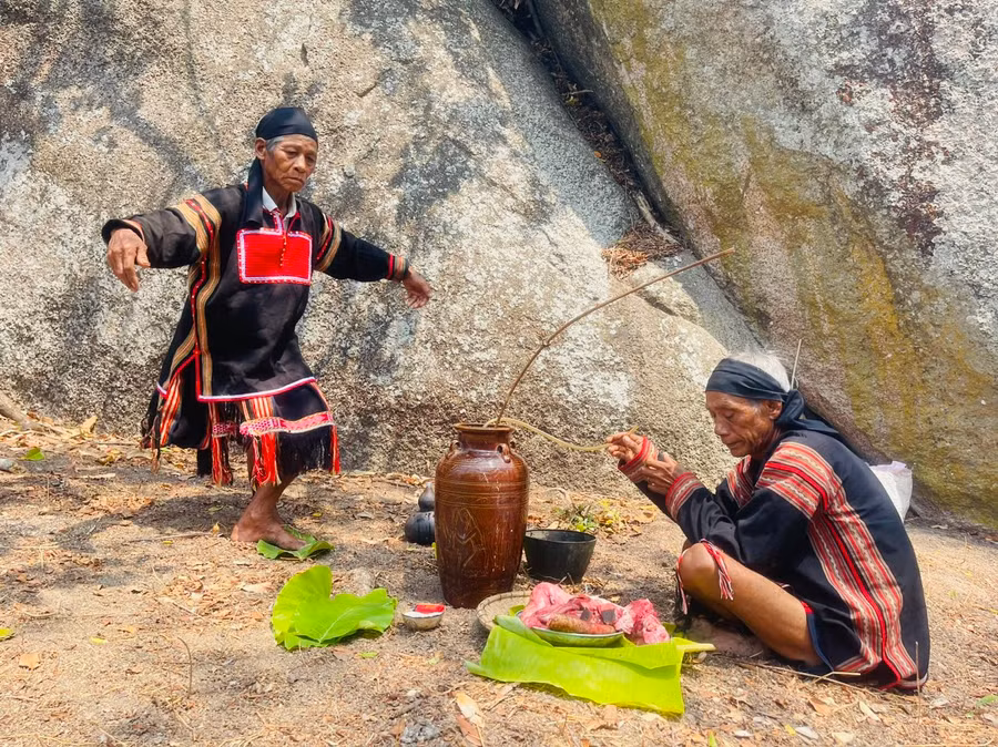 Ông Rah Lan Hieo (đững) làm động tác xoang như đại bàng cất cánh để gửi lời thỉnh cầu đến thần linh. Ảnh: Vũ Chi