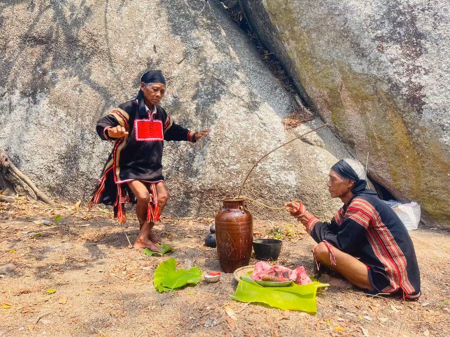 Ông Siu Phơ (ngồi) và ông Rah Lan Hieo (đứng) thực hiện nghi lễ cúng cầu mưa. Ảnh: Vũ Chi