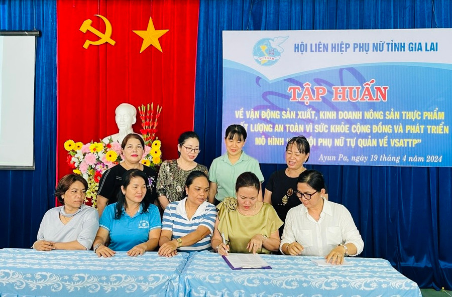 Các thành viên trong “Chi hội phụ nữ tự quản về vệ sinh an toàn thực phẩm” ký cam kết sản xuất, kinh doanh sản phẩm đạt an toàn về chất lượng. Ảnh: Vũ Chi