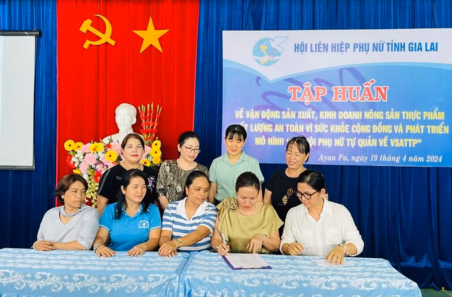 Các thành viên trong “Chi hội phụ nữ tự quản về vệ sinh an toàn thực phẩm” ký cam kết sản xuất, kinh doanh sản phẩm đạt an toàn về chất lượng. Ảnh: Vũ Chi