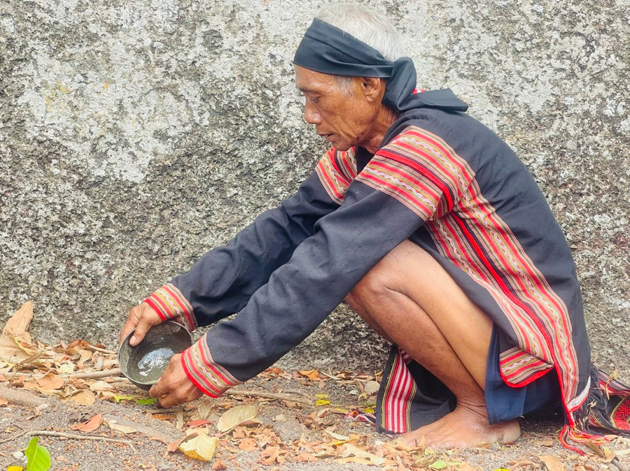 Ông Siu Phơ đổ rượu, thịt vào khe núi để tưởng nhớ các đời Vua Lửa trước đây. Ảnh: Vũ Chi Ông Siu Phơ đổ rượu, thịt vào khe núi để tưởng nhớ các đời Vua Lửa trước đây. Ảnh: Vũ Chi