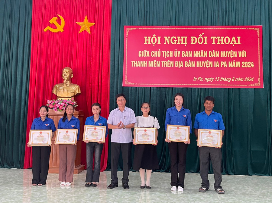 Chủ tịch UBND huyện Huỳnh Văn Trường (đứng giữa) tặng giấy khen các tập thể, cá nhân có thành tích tiêu biểu trong xây dựng nông thôn mới tại địa phương. Ảnh: Vũ Chi