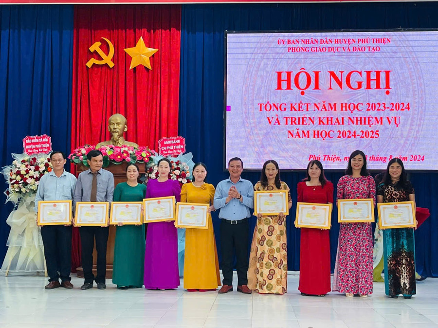 Phó Bí thư Thường trực Huyện ủy Phú Thiện Vũ Hồng Duy (thứ 5 từ phải sang) trao danh hiệu Tập thể lao động tiên tiến cho các đơn vị trường học . Ảnh: Vũ Chi