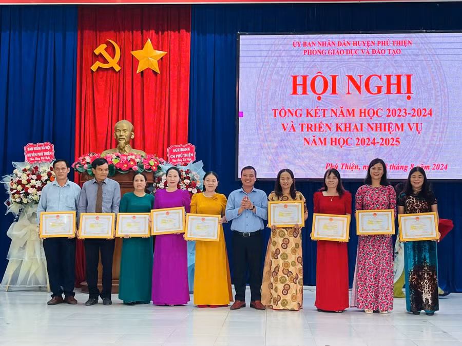 Phó Bí thư Thường trực Huyện ủy Phú Thiện Vũ Hồng Duy (thứ 5 từ phải sang) trao danh hiệu Tập thể lao động tiên tiến cho các đơn vị trường học . Ảnh: Vũ Chi