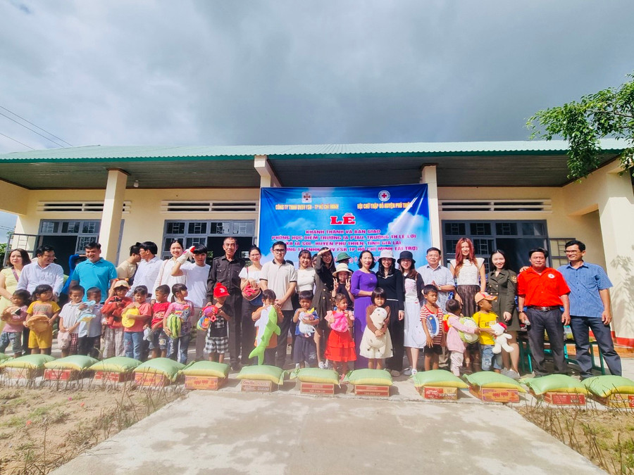 Đại diện nhà tài trợ cùng chính quyền địa phương tặng quà cho học sinh có hoàn cảnh khó khăn học tại điểm trường Ia Ptau. Ảnh: Vũ Chi