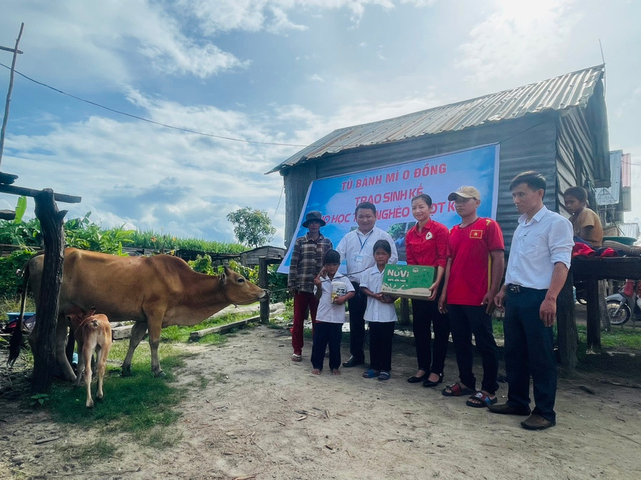 Thầy Tùng cùng Hội Chữ thập đỏ huyện, Ban Giám hiệu Trường Tiểu học và THCS Đinh Núp trao bò và quà cho em Đinh Tháng. Ảnh: Vũ Chi