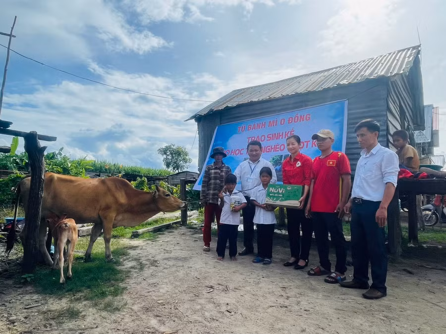 Thầy Tùng cùng Hội Chữ thập đỏ huyện, Ban Giám hiệu Trường Tiểu học và THCS Đinh Núp trao bò và quà cho em Đinh Tháng. Ảnh: Vũ Chi