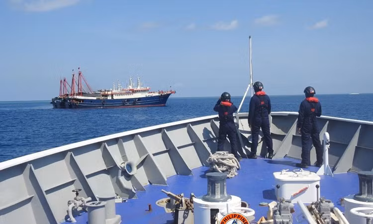 Cảnh sát biển Philippines quan sát tàu cá được cho là của lực lượng dân quân Trung Quốc ở bãi Sa Bin hồi tháng 4/2021. Ảnh: Reuters