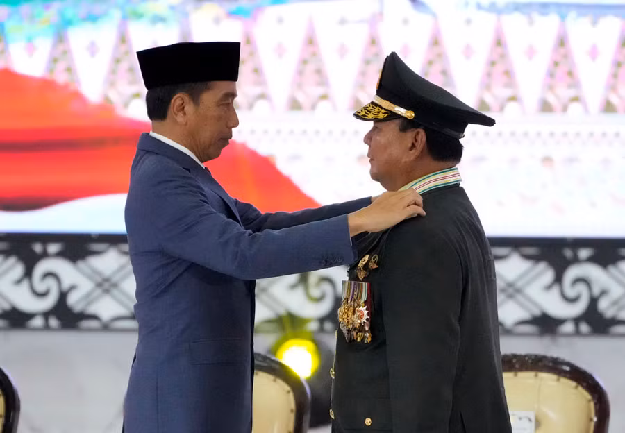 Tổng thống Joko Widodo (trái) đeo cầu vai 4 sao cho Bộ trưởng quốc phòng Subianto ( người sẽ làm tổng thống Indonesia vào tháng 10 tới) hồi tháng 2/2024. Ảnh: AP