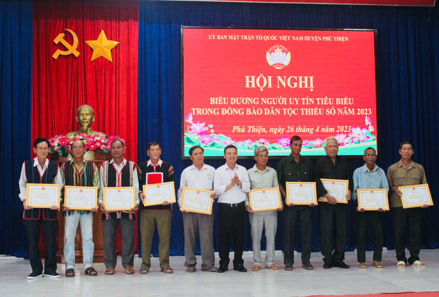 Phó Bí thư Huyện ủy Vũ Hồng Duy (đứng giữa) tặng giấy khen cho người uy tín tiêu biểu trên địa bàn. Ảnh: Vũ Chi