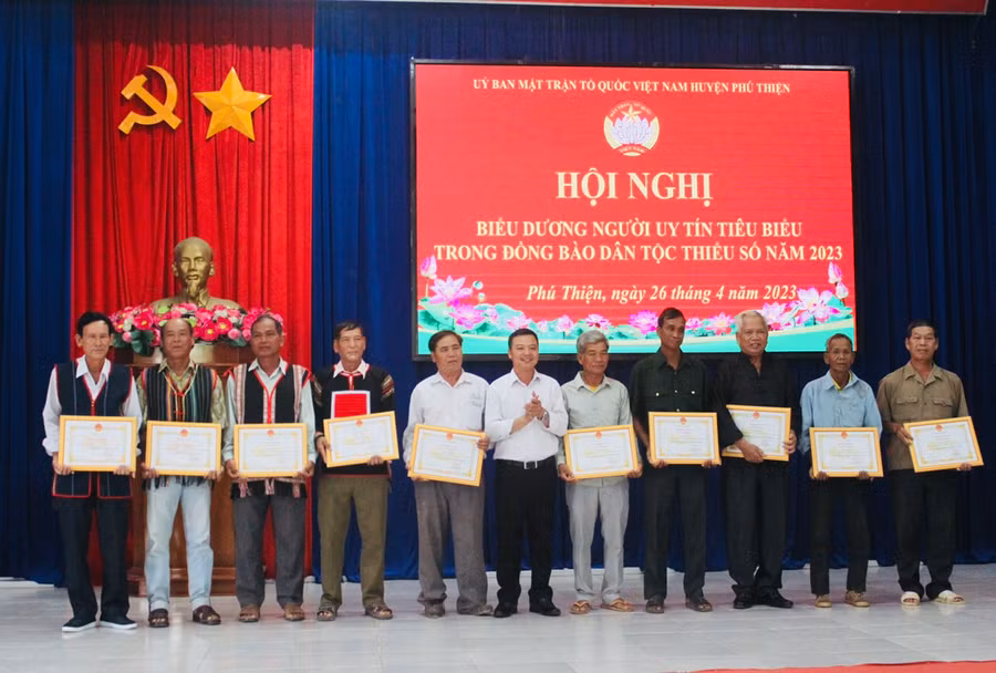 Phó Bí thư Huyện ủy Vũ Hồng Duy (đứng giữa) tặng giấy khen cho người uy tín tiêu biểu trên địa bàn. Ảnh: Vũ Chi