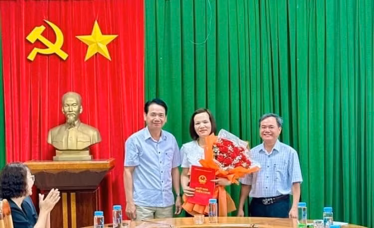 Phó Chủ tịch HĐND thị xã Mai Thế Phụng (bìa trái) và Phó Chủ tịch UBND thị xã Đặng Xuân Toàn (bìa phải) trao quyết định và tặng hoa chúc mừng tân Chánh Văn phòng HĐND-UBND thị xã. Ảnh: Nguyễn Sang